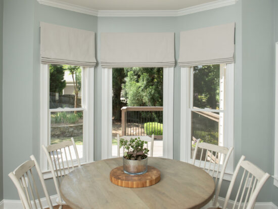 Stationary flat roman shades in bay window