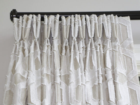 Two finger pinch pleat drapery hung on traversing tracks